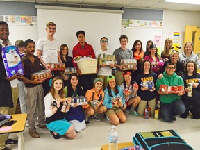 Students in Stephanie Kennedy's social justice class hold up canned goods from their October Campaign. The drive raised over 7,000 cans before Hallowe'en, and those cans will go towards Outreach for Hunger in Chatham.