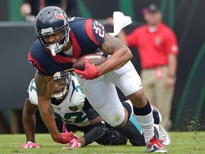 Houston Texans running back Arian Foster (23) tries to keep to his feet as he runs past Jacksonville Jaguars cornerback Aaron Colvin, left, during the first half of an NFL football game in Jacksonville, Fla., Sunday, Oct. 18, 2015. (AP Photo/Phelan M. Ebenhack)