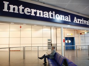 A man waits for arriving passengers in the international arrivals hall at Gatwick airport's north terminal, south of London, in this November 30, 2011 file photo. REUTERS/Andrew Winning