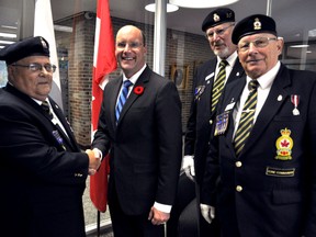 Royal Canadian Legion members Norm Pichie (left), Caspar Koevoets and Ross Seip present London Mayor Matt Brown with the first poppy of the 2015 Poppy Campaign in London Ont. October 27, 2015. CHRIS MONTANINI\LONDONER\POSTMEDIA NETWORK