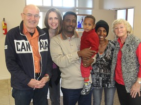 Fred Boven, left, pastor Heidi De Jonge, second from left, and Greta Boven, right, all from the Westside Fellowship Christian Reformed Church, stand with newly arrived Eritrean refugee family Goitom Weldemarian, his son Philmon and wife Abrahet in Kingston on Friday. (Michael Lea/The Whig-Standard)