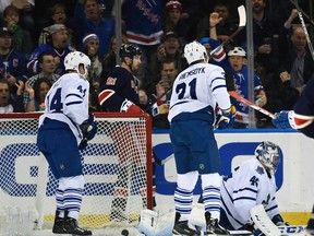 Toronto Maple Leafs defenseman Morgan Rielly, left wing James van Riemsdyk and goalie Jonathan Bernier react as the New York Rangers celebrate right wing Mats Zuccarello's goal during the first period of an NHL hockey game on Friday, Oct. 30, 2015, in New York. (AP Photo/Kathy Kmonicek)