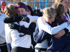 Players from Marymount Academy and College Notre Dame embrace during a ceremony to honour Marymount student Kodee Daoust prior to a girls flag football playoff game at James Jerome Sports Complex in Sudbury, Ont. on Friday October 30, 2015. Daoust was killed in a car accident on October 28. John Lappa/Sudbury Star/Postmedia Network