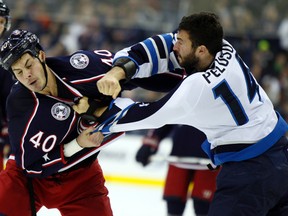 Columbus Blue Jackets' Jared Boll, left, and Winnipeg Jets' Anthony Peluso fight during the second period on Saturday. (AP/Paul Vernon)