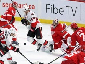 Ottawa Senators' Erik Karlsson (65), centre, reacts to a flying puck in front of  Detroit Red Wings' goaltender Petr Mrazek (34), second from right, as his teammate Brendan Smith (2) looks on during second period NHL hockey action, in Ottawa, on Saturday, Oct. 31, 2015. 
THE CANADIAN PRESS/Fred Chartrand