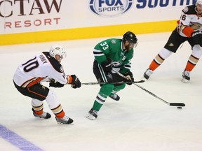 Alex Goligoski #33 of the Dallas Stars skates the puck past Corey Perry #10 of the Anaheim Ducks in the third period at American Airlines Center on October 27, 2015 in Dallas, Texas.   
Ronald Martinez/AFP