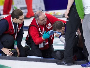 Brad Gushue was defeated by Steve Laycock 5-2 Saturday, Oct. 31, 2015, in quarter-final action at the Grand Slam of Curling Masters in a match that saw Gushue fall and hit his head on the ice in the fourth end. He returned to the ice later in the day with stitches above his right eye. Gushue is seen third from left receiving medical treatment after his fall. (THE CANADIAN PRESS/HO-Anil Mungal)