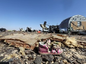 A child's shoe is seen in front of debris from a Russian airliner which crashed at the Hassana area in Arish city, north Egypt, November 1, 2015. REUTERS/Mohamed Abd El Ghany