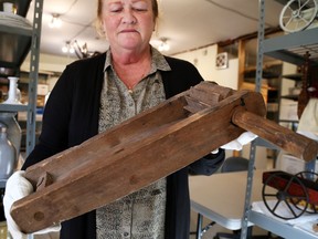 Glanmore National Historic Site curator Rona Rustige holds a gas rattle stored on Glanmore's third floor  on Friday October 30, 2015 in Belleville, Ont. The rattle was used in World War 1 to warn soldiers in the trenches of incoming gas. Tim Miller/Belleville Intelligencer/Postmedia Network