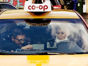 A city Inspector seals the meter in a taxi on Sunday at the lower $3.25 starting fare. (CRAIG ROBERTSON, Toronto Sun)