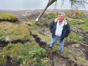 Norm Van Elslander stands on the eroding riverbank behind his Dunkirk Drive home in Winnipeg. Van Elslander estimates that he has lost about 70 feet of property since he bought his home. (Brian Donogh/Winnipeg Sun/Postmedia Network)