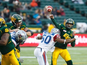 Edmonton's Mike Reilly (13) is tackled by Montreal's Henoc Muamba (50) during the first half of a CFL game between the Edmonton Eskimos and the Montreal Alouettes at Commonwealth Stadium in Edmonton, Alta.. on Sunday November 1, 2015. Ian Kucerak/Edmonton Sun/Postmedia Network