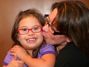 Seven-year-old Nevada Khan (left), who has Down's syndrome, gets a kiss from her mother Caroline Pearce. (Brian Donogh/Winnipeg Sun/Postmedia Network)
