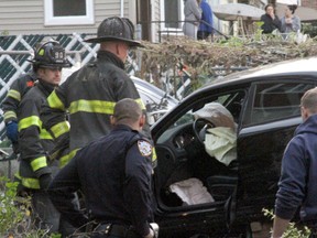 First responders examine an automobile after its driver lost control and plowed into a group of trick-or-treaters in New York, Saturday, Oct. 31, 2015. Three people were killed, including a 10-year-old girl. Several others were injured. (AP Photo/David Greene)
