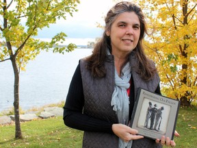 Silvia Pecota, a KIngston artist, photographer and poet, holds her new book, Remembering Our Fallen, on Saturday. (Steph Crosier/The Whig-Standard)