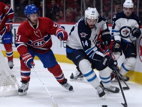 Nov 1, 2015; Montreal, Quebec, CAN; Winnipeg Jets forward Anthony Peluso (14) moves the puck and Montreal Canadiens forward David Desharnais (51) defends during the second period at the Bell Centre. Mandatory Credit: Eric Bolte-USA TODAY Sports