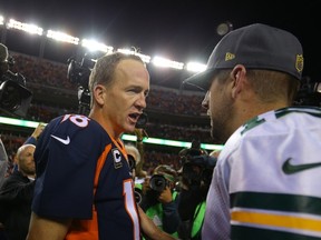 Quarterbacks Aaron Rodgers #12 (R) of the Green Bay Packers and Peyton Manning #18 (L) of the Denver Broncos talk while surrounded by media after the Broncos 29-10 win at Sports Authority Field at Mile High on November 1, 2015 in Denver, Colorado.   Justin Edmonds/Getty Images/AFP