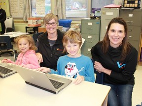 Enbridge's Cynthia Lockrey and High Park Public School teacher Karis Gervais join Grade 3 students Tyla Lucas and Mason Kinsman as they switch on two of the school's recently acquired refurbished laptops, donated by Enbridge. (CARL HNATYSHYN/ SARNIA THIS WEEK/ POSTMEDIA NETWORK)