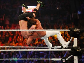 Seth Rollins suplexes John Cena at WWE's SummerSlam event earlier this year in Brooklyn. Rollins is slated to appear in Winnipeg at a WWE event on Dec. 20. (JP Yim/Getty Images/AFP file)