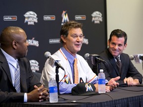 Don Mattingly speaks to members of the media accompanied by Michael Hill, president of baseball operations for the Miami Marlins, and Marlins president David Samson after Mattingly was introduced as the new Marlins baseball team manager in Miami on Nov. 2, 2015. (AP Photo/Wilfredo Lee)