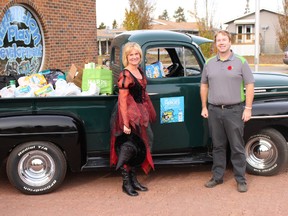 Sharleen Moses, left, and Mike Webb, right, pose in front of a truck filled with non-perishables set to be donated to the Vermilion Food Bank.