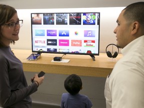 An Apple employee demonstrates the new Apple TV to a shopper at an Apple Store in Los Angeles, California, October 30, 2015.  REUTERS/Jonathan Alcorn