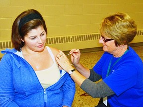 Registered Nurse MaryAnne Van Bakel gives Jenny Hall an influenza vaccination during the flu clinic at the Mitchell and District Community Centre Oct. 29. Flu shots are now available from your family doctor and at participating pharmacies.  GALEN SIMMONS/MITCHELL ADVOCATE