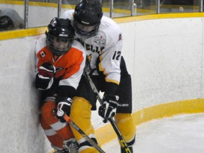 Drew MacLean (12) of the Mitchell Bantams finishes his check behind the Kincardine net during WOAA regular season action last Friday, Oct. 30. The Meteors rallied from a 2-0 deficit to win, 6-4. ANDY BADER/MITCHELL ADVOCATE