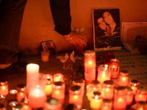 A woman places a candle outside a nightclub, where a fire broke out on Friday, in Bucharest, Romania October 31, 2015. A fire in a Bucharest nightclub killed 27 people and injured 184 during a rock concert that featured fireworks late on Friday, Romanian government officials and witnesses said. In one of the capital's worst disasters in decades, about 400 people, mostly young adults, stampeded for the only available exit as the club in the basement of a Communist-era sport-shoe factory filled with smoke. (REUTERS/Inquam Photos)