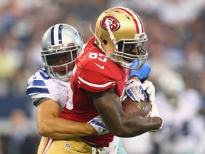 Vernon Davis of the San Francisco 49ers runs the ball against Sterling Moore of the Dallas Cowboys at AT&T Stadium in Arlington on Sept. 7, 2014. (Ronald Martinez/Getty Images/AFP)