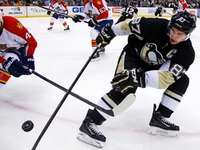 Florida Panthers' Erik Gudbranson knocks the puck off the stick of Pittsburgh Penguins' Sidney Crosby during the second period of an NHL hockey game in Pittsburgh on Oct. 20, 2015. (AP Photo/Gene J. Puskar)