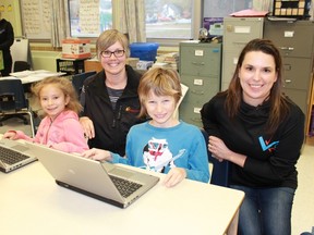 Enbridge's Cynthia Lockrey and High Park Public School teacher Karis Gervais join grade 3 students Tyla Lucas and Mason Kinsman as they switch on two of the school's recently acquired refurbished laptops, donated by Enbridge. 
CARL HNATYSHYN/SARNIA THIS WEEK