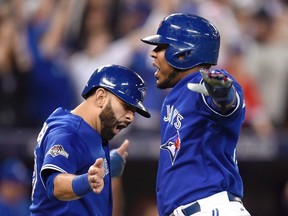 Toronto Blue Jays' Jose Bautista, left, and Edwin Encarnacion celebrate after scoring on a three-run double by Troy Tulowitzki during sixth inning of Game 5 of the American League Championship Series against the Kansas City Royals in Toronto on Oct. 21, 2015. (THE CANADIAN PRESS/Frank Gunn)