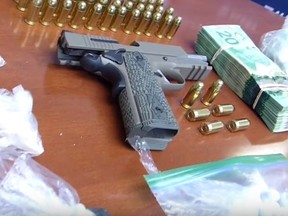 A pistol, drugs and money seized in a Fort McMurray bust. (SUPPLIED)