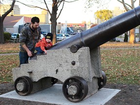 Evan Dacey plays on the 'Big Tom' cannon with his father, Bryan, after the cannon was returned to Veterans Park Monday. The historic cannon is back in time for Remembrance Day after being moved away more than 50 years ago to Canatara Park. (Tyler Kula/Sarnia Observer/Postmedia Network)