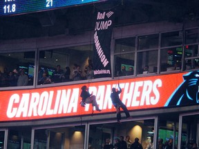 Protestors unfurl a banner from the upper deck of Bank of America stadium in the second half of an NFL game between the Panthers and Colts in Charlotte, N.C., on Monday, Nov. 2, 2015. (Mike McCarn/AP Photo)