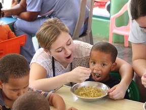 Children at a nutrition centre in the Dominican Republic get a hand from Melissa Chopcian and other participates in an awareness trip Sarnia-based Rayjon organized in 2014. Rayjon's sixth annual Pastafest fundraiser runs Thursday, 5 p.m. to 7 p.m., at the Danta Club in Sarnia. (Handout/Sarnia Observer/Postmedia Network)