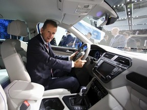 Volkswagen Passenger Cars CEO Herbert Diess poses for pictures behind the wheel in a new Tiguan GTE at the 44th Tokyo Motor Show in Tokyo October 28, 2015. (REUTERS/Thomas Peter)