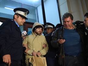 Alin Anastasescu one of the owners of the "Colectiv" nightclub where a fire occured last week is accompanied by police officers after a hearing by prosecutors in Bucharest on November 2, 2015. (AFP/DANIEL MIHAILESCU)