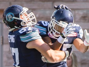 Toronto Argonauts' Diontae Spencer, right, celebrates with teammate Jeff Keeping after scoring a touchdown against the Montreal Alouettes during first half CFL football action in Montreal, Monday, October 12, 2015. THE CANADIAN PRESS/Graham Hughes