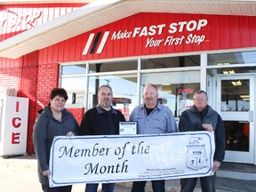 Julie Leonard and Marc Johnson flank the owners of the Faststop Truck stop (left) Mario Vachon and his dad Mariel Vachon as they present them with a plaque and the honour of displaying the Board of Trade Member of the Month sign.