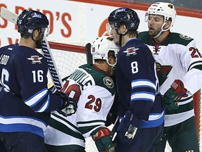 Winnipeg Jets forward Andrew Ladd bumps Minnesota Wild forward Jason Pominville into Jacob Trouba during NHL action in Winnipeg on Sun., Oct. 25, 2015. Kevin King/Winnipeg Sun/Postmedia Network