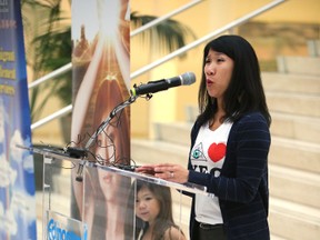 Sarah Chan speaks to the media on the action plan to prevent sex trafficking at city hall in Edmonton, Alberta on November 3, 2015. Sarah's daughter Alice is with her at the podium. Perry Mah/Edmonton Sun