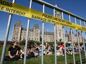 Demonstrators sit after crossing a police barricade during a protest against the Keystone XL pipeline on Parliament Hill in Ottawa September 26, 2011. Dozens were arrested in the protest against the pipeline that, if completed, will stretch from Canada to the gulf coast of the United States.      REUTERS/Chris Wattie