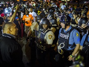 St Louis County police officers interact with anti-police demonstrators during protests in Ferguson, Missouri August 10, 2015. Police in riot gear clashed with protesters who had gathered in the streets of Ferguson early on Tuesday to mark the anniversary of the police shooting of an unarmed black teen whose death sparked a national outcry over race relations. REUTERS/Lucas Jackson