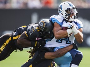 Toronto Argonauts' Anthony Coombs is tackled by Hamilton Tiger-Cats' Simoni Lawrence in Hamilton September 7, 2015.  (REUTERS/Mark Blinch)