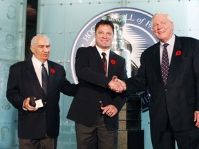Hockey Hall of Fame inductee Dino Ciccarelli accepts his ring from Chairman of the Hockey Hall of Fame’s Board of Directors Jim Gregory (left) and Co-Chairman of Hockey Hall of Fame Selection Committee Bill Hay (right) in Toronto, November 8, 2010. (REUTERS/Mark Blinch)