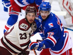 Peterborough Petes' Hunter Garlent (23) fights for position against Kitchener Rangers' Ryan MacInnis during first period OHL action on Thursday October 29, 2015 at the Memorial Centre in Peterborough, Ont. (Clifford Skarstedt, Postmedia Network)