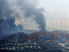 Smoke rises from shipping containers after explosions at Binhai new district in Tianjin, China, August 13, 2015. Two massive explosions caused by flammable goods ripped through an industrial area in the northeast Chinese port city of Tianjin late on Wednesday, killing 17 people and injuring as many as 400, official Chinese media reported. REUTERS/Stringer