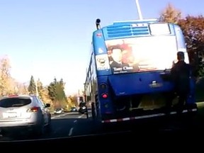 A man is seen hanging off of a York Regional Transit bus Tuesday, Nov. 3, 2015. (YouTube framegrab)